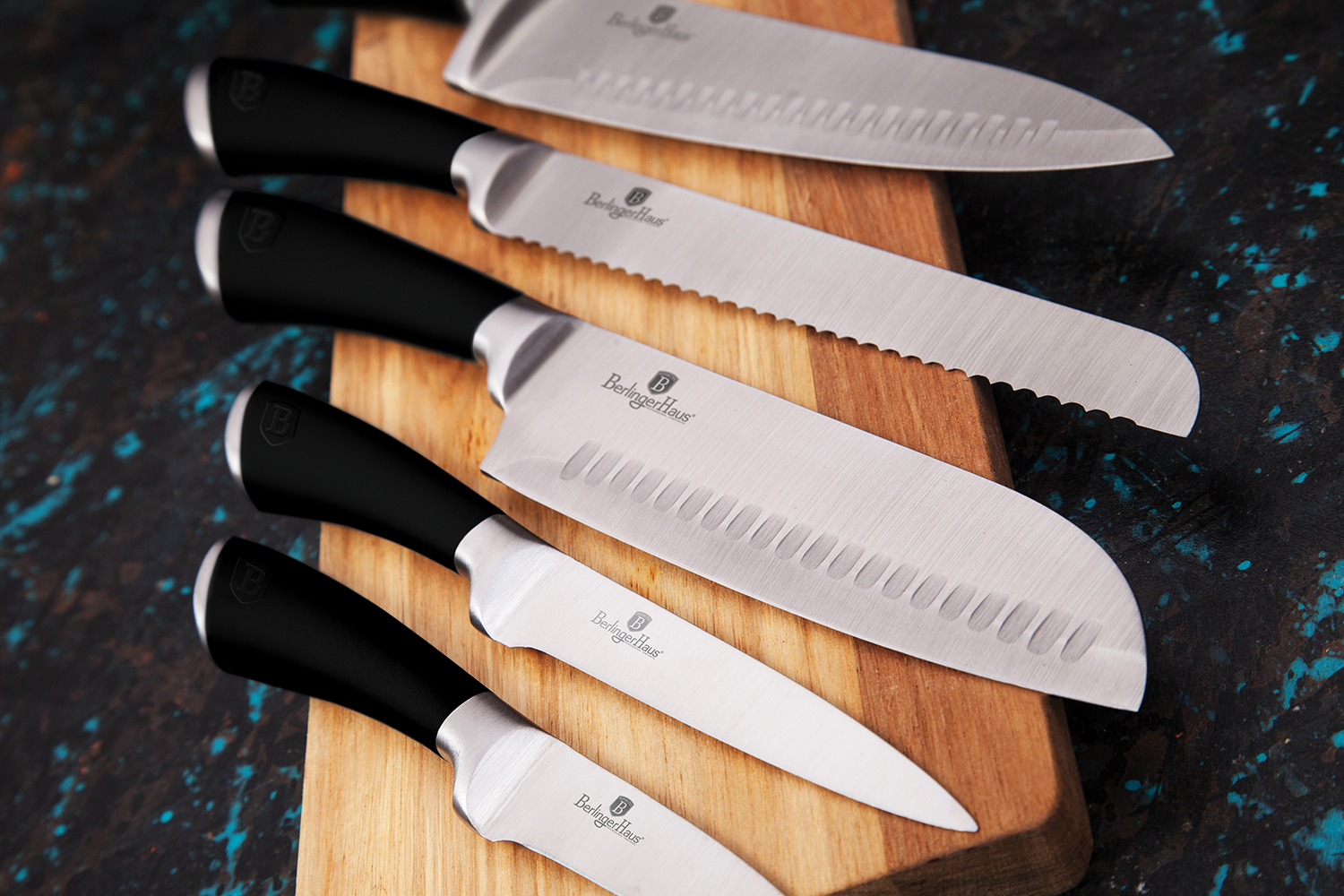 Set of five modern kitchen knives on wooden chopping board