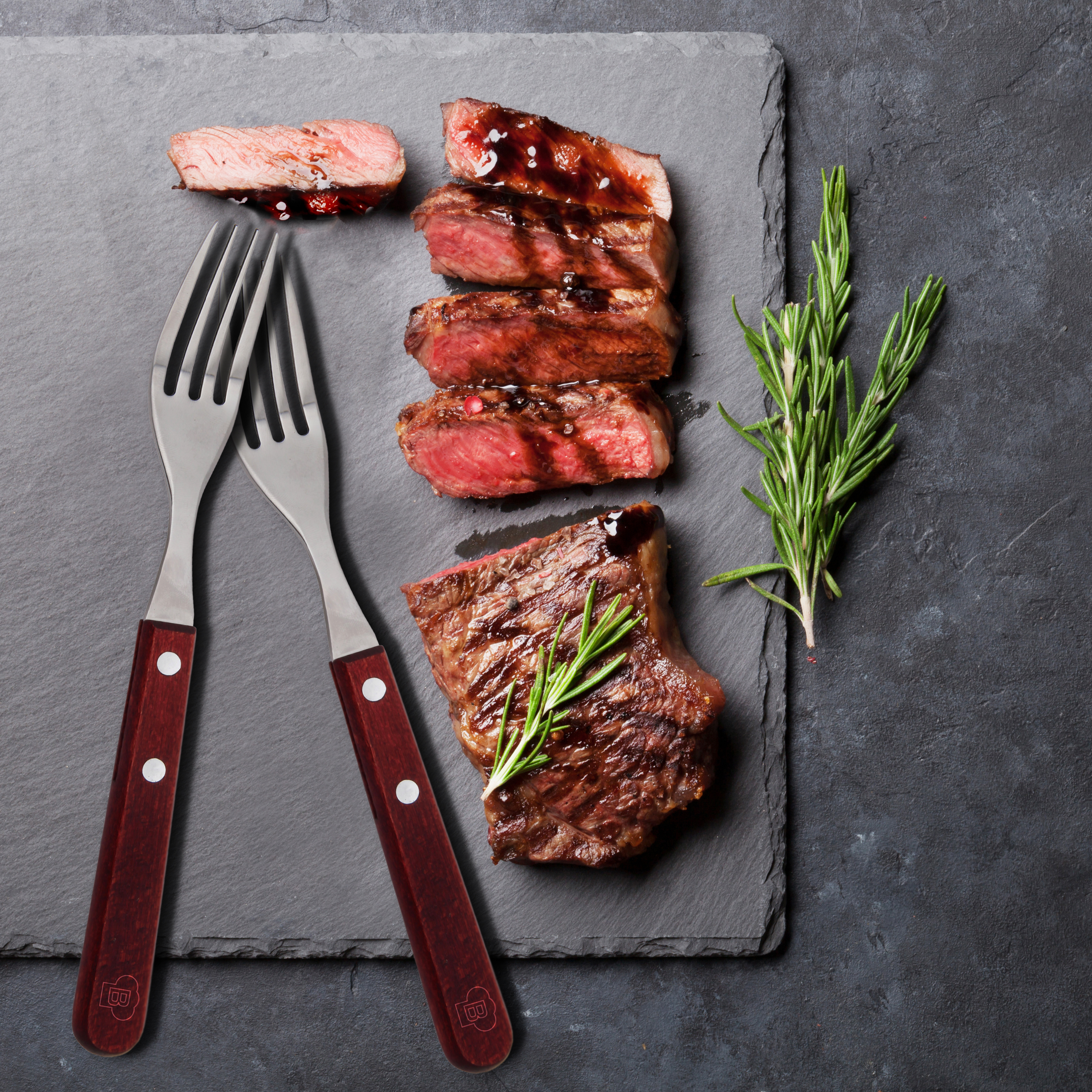 Grilled sliced beef steak with balsamico and rosemary on stone t